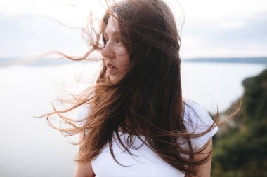 Rüzgarlı saçlı gezgin kız kaya dağının tepesinde rahatlatıcı, 