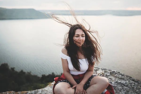 Viajes y Meditación. Hipster chica con el pelo ventoso sentado y —  Fotos de Stock