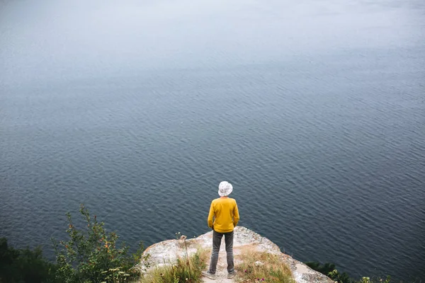 Hipster-Teenager in gelbem Pullover steht auf Felsbrocken — Stockfoto