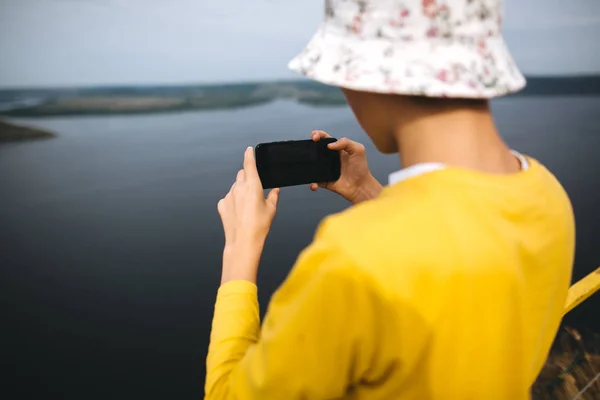 Хипстерский подросток фотографирует на телефон удивительный вид на реку — стоковое фото