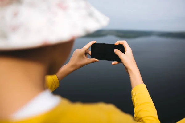 Hipster teenager taking photo on phone of amazing view on river — Stock Photo, Image