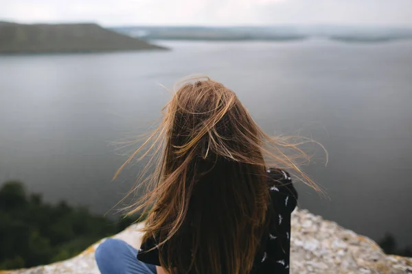 Назад дівчина-гіпстер, що сидить на вершині скельної гори з красунею — стокове фото