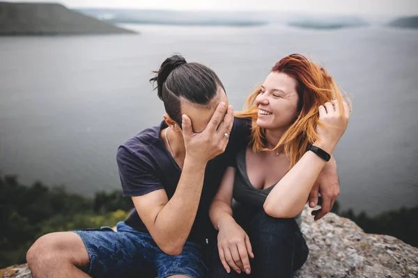 Gelukkig hipster paar zitten en lachen op de top van Rock bergen — Stockfoto