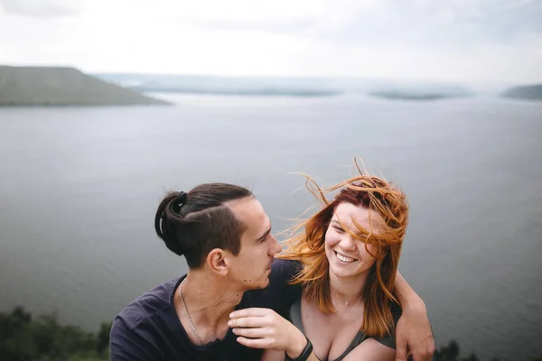 Gelukkig hipster paar zitten en lachen op de top van Rock bergen — Stockfoto