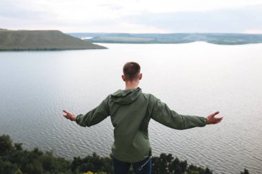Hipster gezgin kaya dağın tepesinde duran ve ha yükselterek