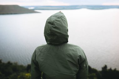 Hipster gezgin kaya dağın tepesinde duran ve bir zevk