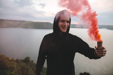 Ultras holigan elinde kırmızı sis bombası tutan, üstünde duran 