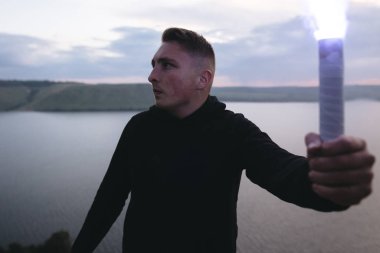 Ultras holigan elinde mavi parlama meşale tutarak, üzerinde duran