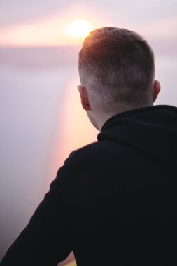 Hipster gezgin kaya dağın tepesinde duran ve bir zevk