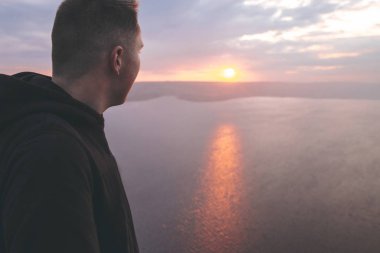 Hipster gezgin kaya dağın tepesinde duran ve bir zevk