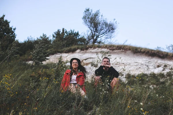 Hipster para siedzi na szczycie Rock Mountain w trawie i enjo — Zdjęcie stockowe