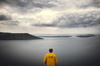Wanderlust ve seyahat konsepti. Sarı rainco hipster gezgin