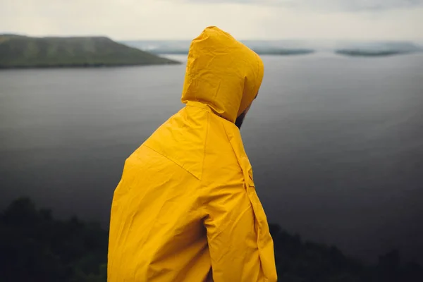 Fernweh und Reisekonzept. Hipster-Reisender im gelben Regenmantel — Stockfoto