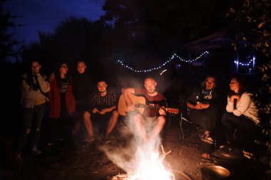 Arkadaşlar gezginler büyük şenlik ateşinde ürpertici, akustik dinleme