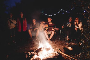 Arkadaşlar gezginler büyük şenlik ateşinde ürpertici, akustik dinleme