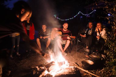 Arkadaşlar gezginler büyük şenlik ateşinde ürpertici, akustik dinleme