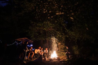 Arkadaşlar gezginler büyük şenlik ateşinde ürpertici, şarkı ve pla şarkı