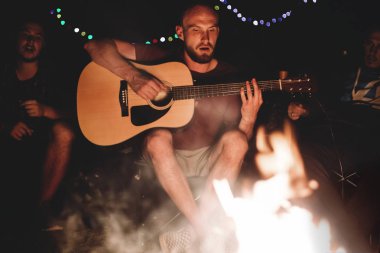 Hipster adam akustik gitar ve ile şarkı çalıyor