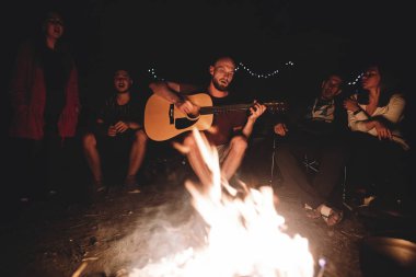 Hipster adam akustik gitar ve ile şarkı çalıyor
