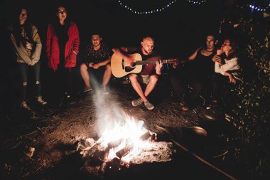 Hipster adam akustik gitar ve ile şarkı çalıyor