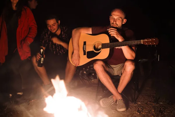 Hipster homme fumant la cigarette et tenant la guitare acoustique à gros — Photo