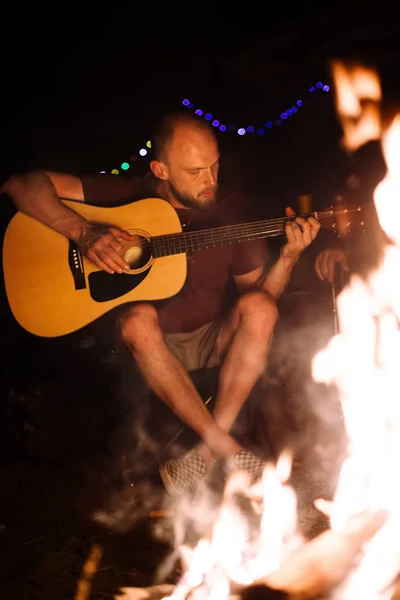 Hipster homem tocando na guitarra acústica e cantando música com fri — Fotografia de Stock