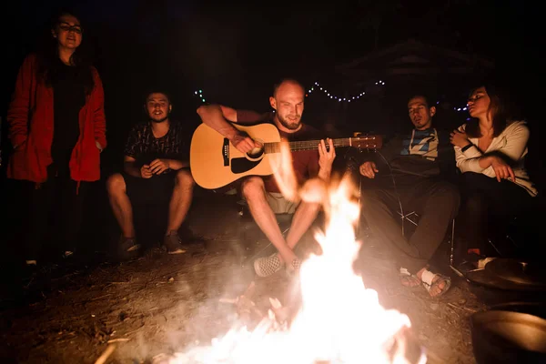 Amis voyageurs se refroidissant au grand feu de joie, chantant des chansons et pla — Photo