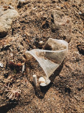 Sahilde plastik kirliliği. Tek kullanımlık plastik bardak ve puro