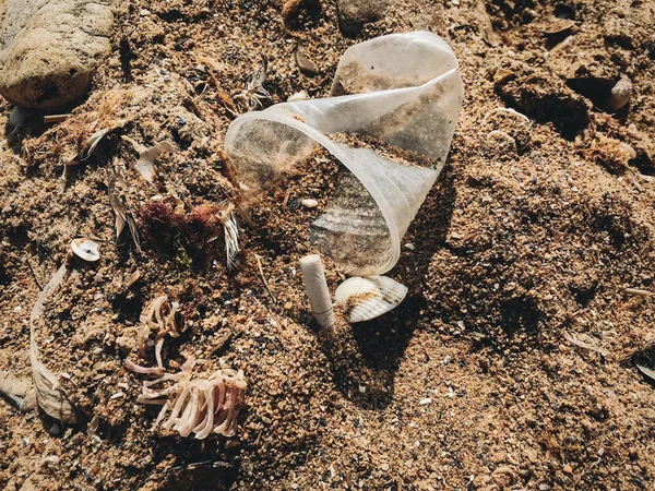 Polusi plastik di pantai. Satu cangkir plastik digunakan di pasir , — Stok Foto