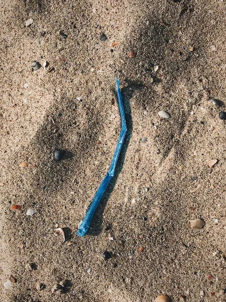 Polusi plastik di pantai. Satu menggunakan sedotan plastik di pasir. — Stok Foto