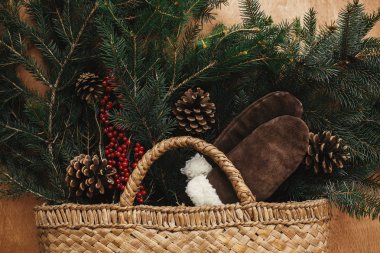 Köknar dalları, rahat eldivenler, koniler ve çilek ile Rustik sepet 