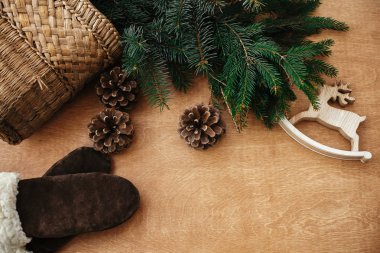 Reindeer oyuncak, eldiven, köknar dalları ve pas konileri ile sepet
