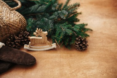 Rustik reindeer oyuncak, eldiven, köknar dalları ve konileri ile sepet 