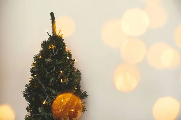 Árvore de Natal e luzes douradas bokeh no quarto branco festivo. Sim. — Fotografia de Stock