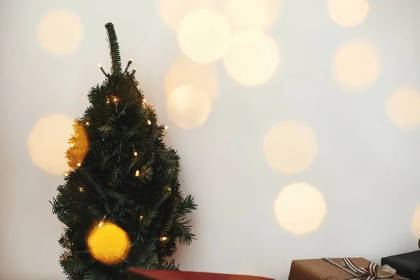 Árbol de Navidad en luces doradas bokeh con regalos elegantes festivos —  Fotos de Stock