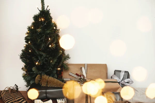 Árbol de Navidad con regalos elegantes festivos en luces doradas bokeh —  Fotos de Stock