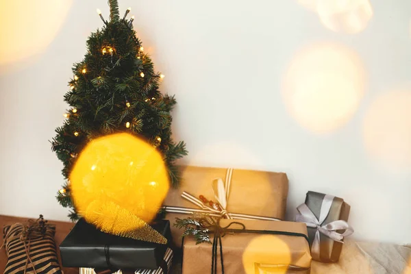 Vánoční stromek s slavnostním stylovým dárkem ve zlatých světlech — Stock fotografie