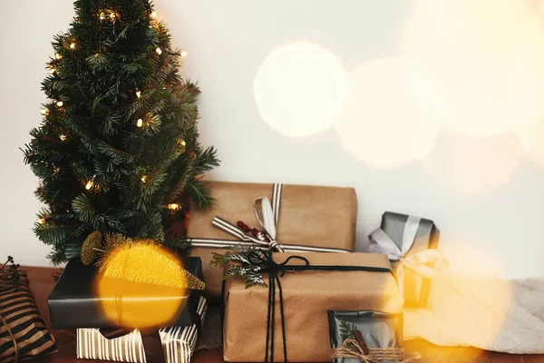 Elegantní dárkové krabice pod vánočním stromkem s slavnostním zlatým lihem — Stock fotografie
