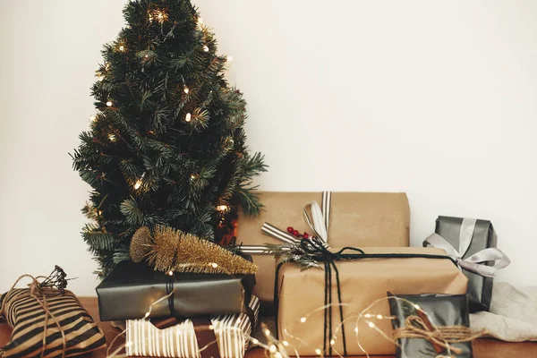 Elegantes cajas de regalo bajo el árbol de Navidad con festivo ligh dorado —  Fotos de Stock