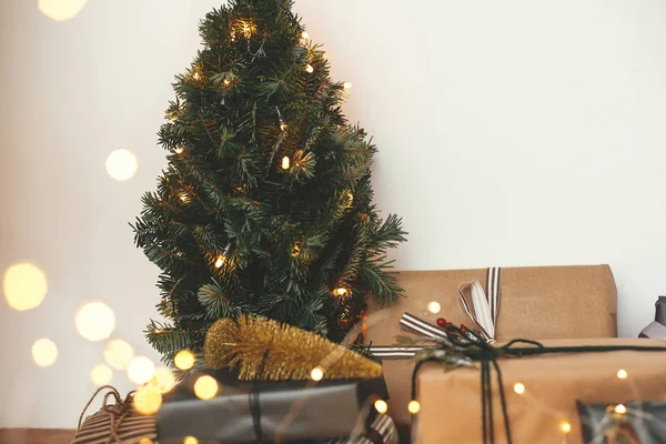 Árbol de Navidad con regalos elegantes festivos en luces doradas bokeh —  Fotos de Stock