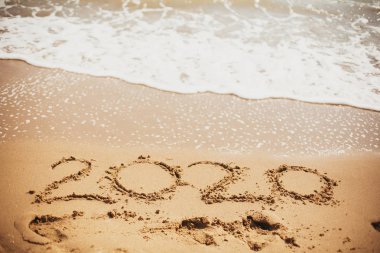 2020 Yeni Yıl. 2020 denizde dalga köpük ile kumlu plajda yazılı