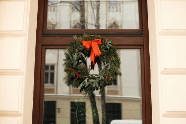 Noel sokak dekoru. Kırmızı yay lı şık noel çelengi