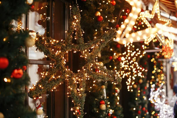 Elegante estrella de Navidad iluminada y ramas de abeto con rojo y —  Fotos de Stock