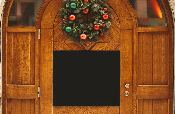 Stylový vánoční věnec s červenými a zelenými ruky a prázdným Bo Stock Fotografie