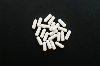 Siyah koyu arka plan üzerinde Magnezyum kapsüller. Düz yatıyordu. Diyet s