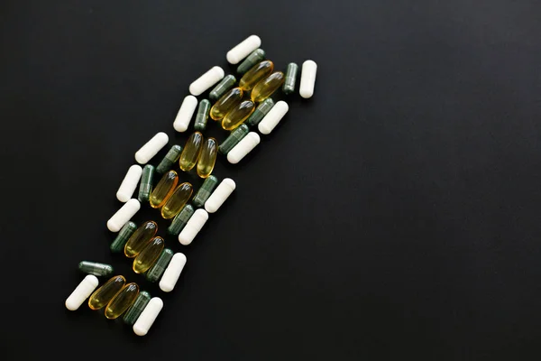 Omega 3, espirulina, clorofila, cápsulas de magnesio en negro oscuro — Foto de Stock