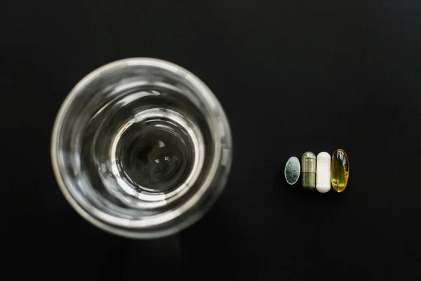 Omega 3, spirulina, klorofylli, magnesiumkapselit lusikassa — kuvapankkivalokuva