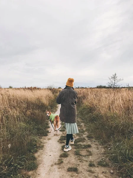 Hipster dívka ve žlutém klobouku a v kabátě kráčí se svým zlatým d — Stock fotografie