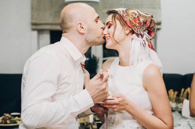 Gelin ve damat kabile resepsiyonunda düğün pastası tadıyorlar.