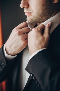 Siyah takım elbiseli şık damat elinde beyaz gömlek, poz
